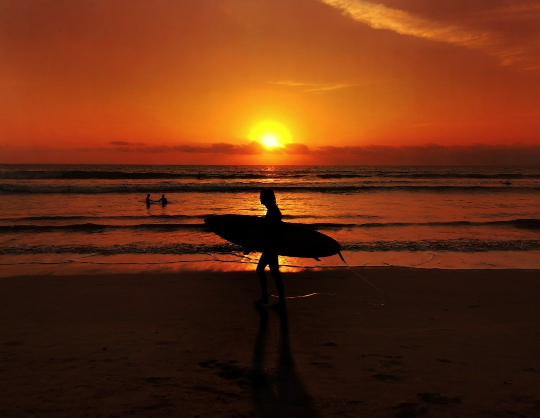 Surfing at Seminyak beach in Bali at sunset