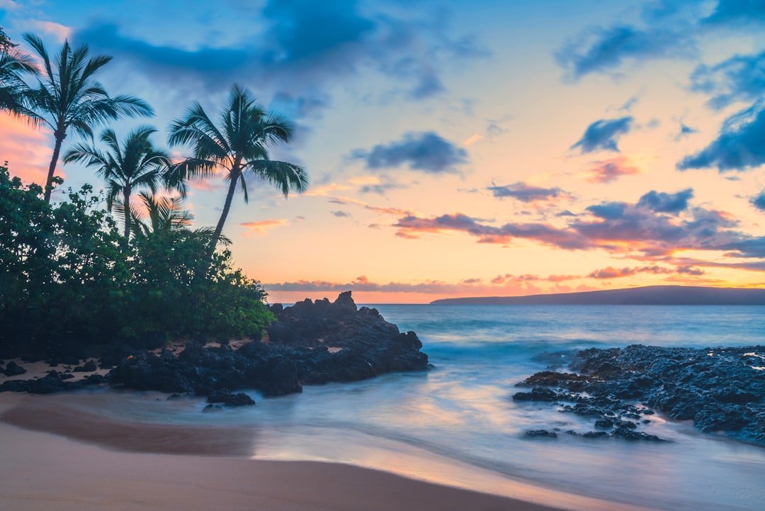 Hawaii tropical beach with volcanic landscape at sunset