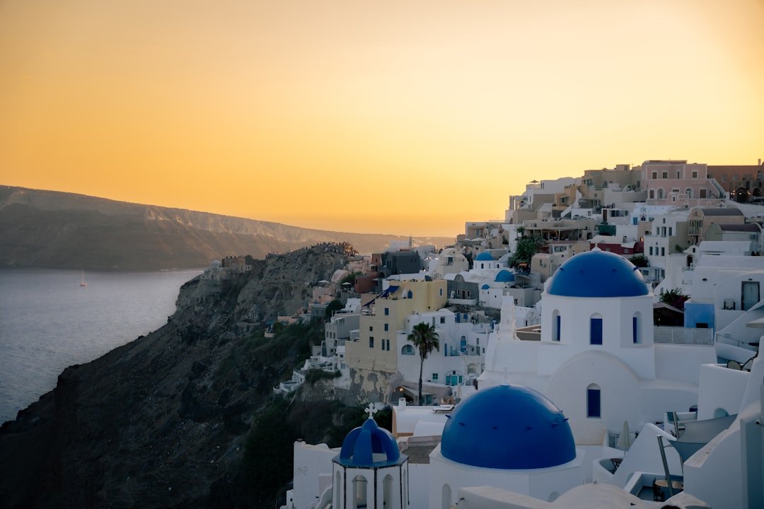 White and blue dome church at sunset in Santorini Greece