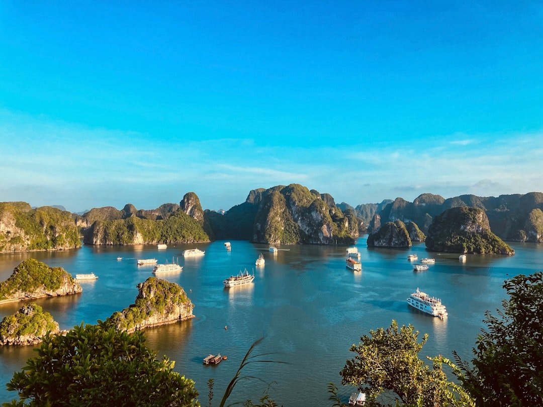 Boat sailing through limestone karsts in Ha Long Bay Vietnam