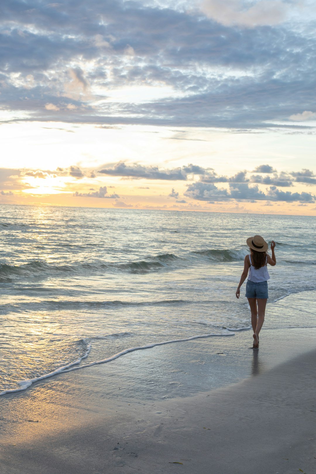 Woman enjoying a solo beach sunset while travelling