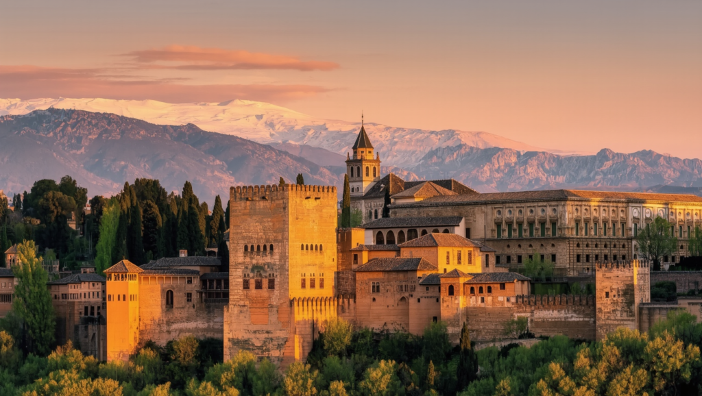 The Alhambra palace in Granada at golden hour with the Sierra Nevada behind
