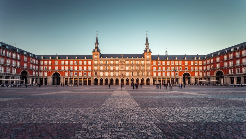 Plaza Mayor in Madrid with arcaded ochre facades in late afternoon sun