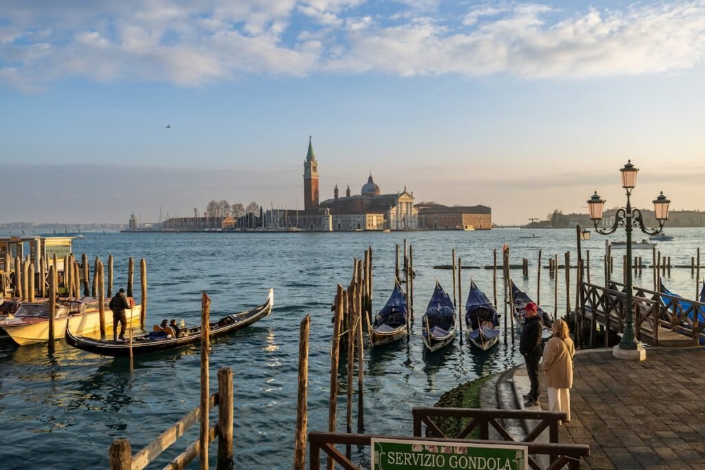 Gondolas moored on the water against the Venice skyline